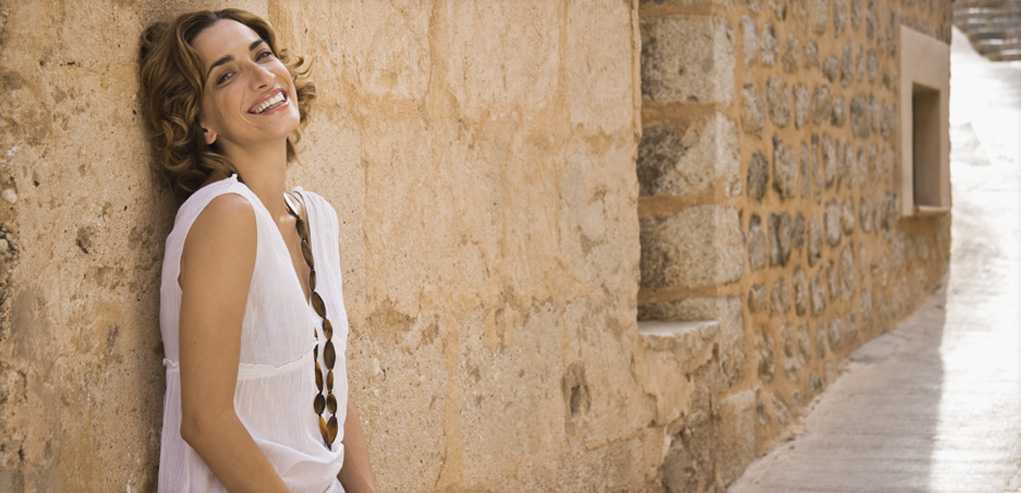 Woman happy with her Results Standing in Alley after Receiving Dermalinfusion Exfoliating Treatment.