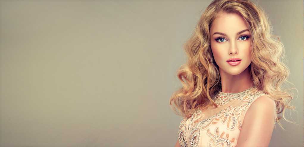 Beautiful soft light portrait of lady with blond curly hair and smooth skin.